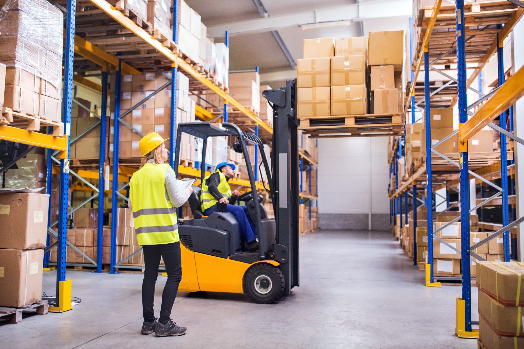 Man on forklift picking products in warehouse
