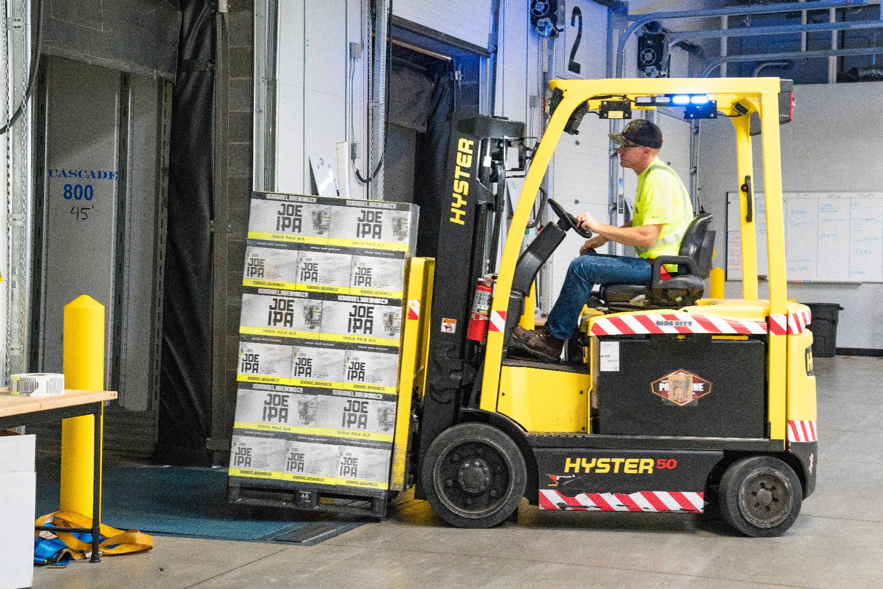 Forklift moving storage boxes in warehouse